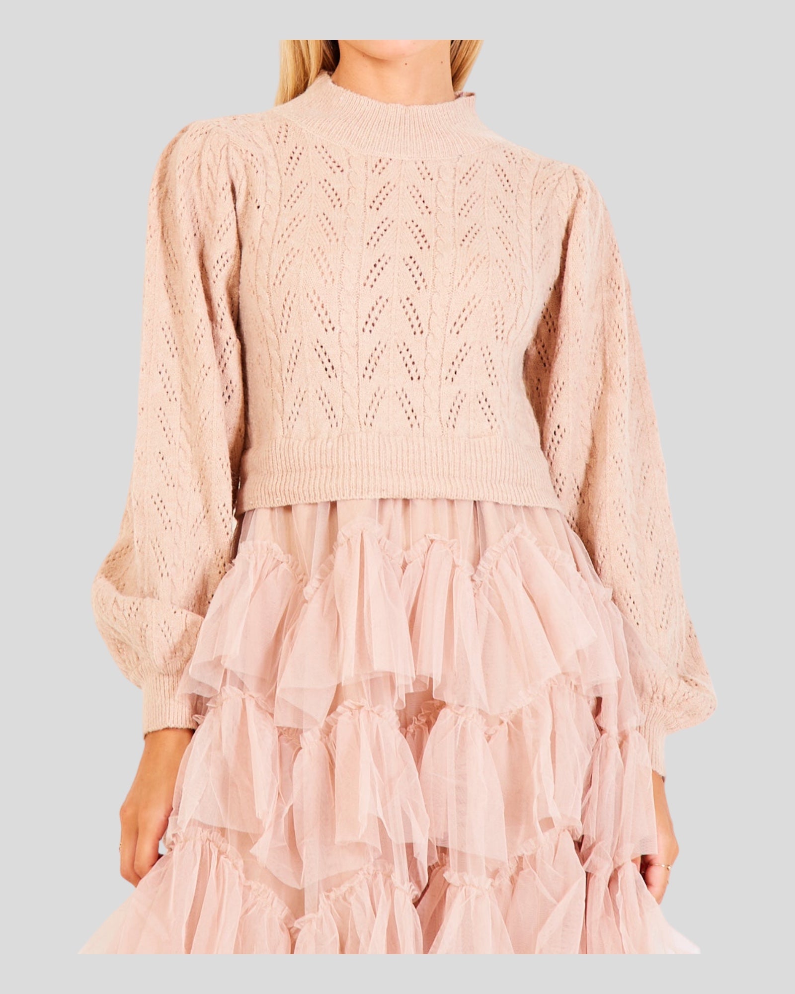 Women's Sweater in a delightful beige/baby pink hue. The design combines the sophistication of a knitted sweater on the upper part with playful tulle ball dress ruffles adorning the skirt. Evoking the iconic "Sex and the City" style, this fashion-forward piece seamlessly blends comfort and elegance