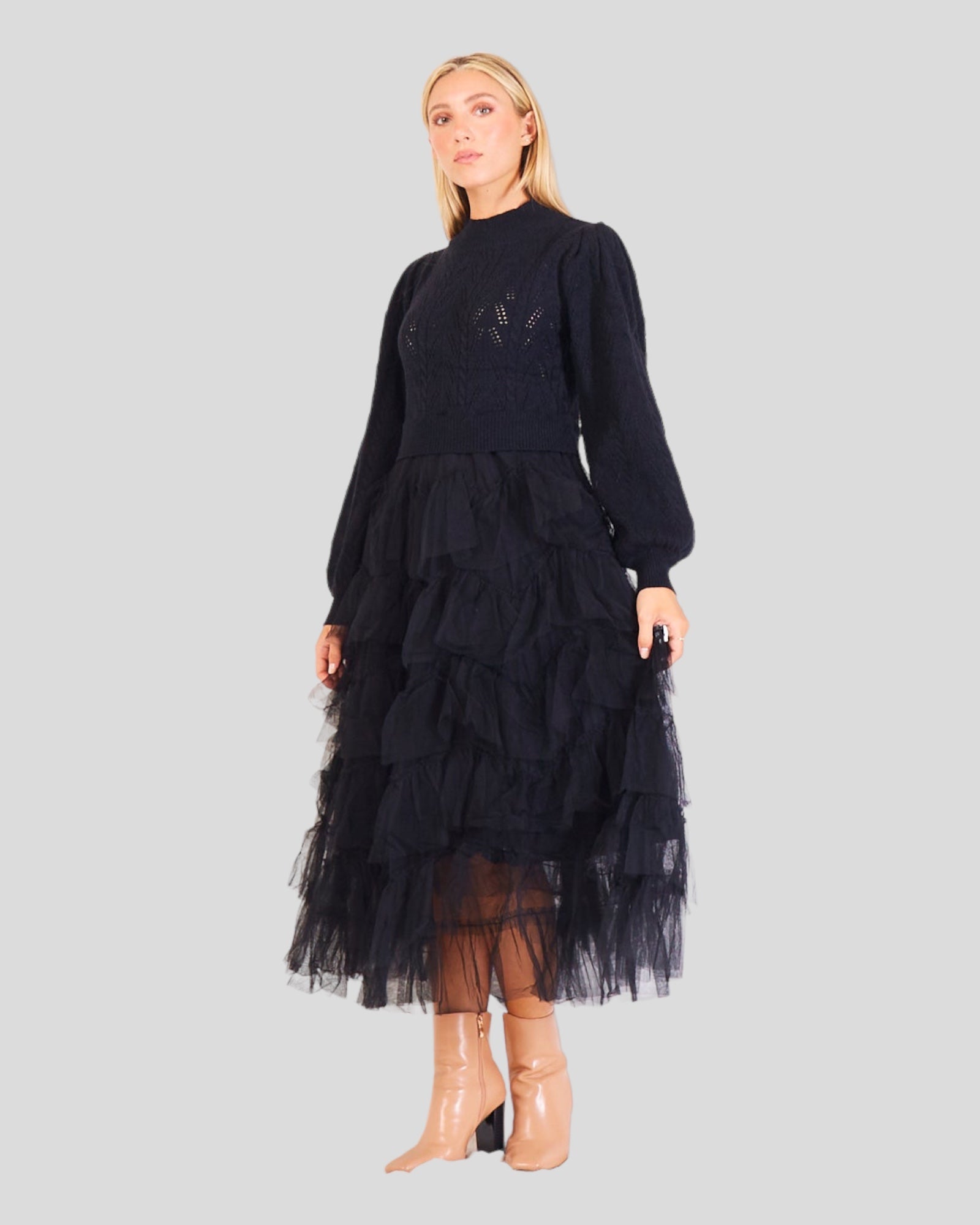 Women's Sweater in a delightful black . The design combines the sophistication of a knitted sweater on the upper part with playful tulle ball dress ruffles adorning the skirt. Evoking the iconic "Sex and the City" style, this fashion-forward piece seamlessly blends comfort and elegance